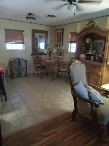 a living room with couches and kitchen view with wooden floor