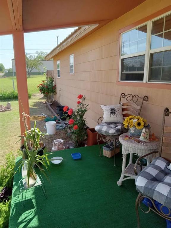 408 East Johnston Street Rotan, TX 79546 - Photo 2 of 18 a front view of a house with a chairs and table in patio