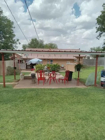a view of a patio with table and chairs potted plants with floor to ceiling window
