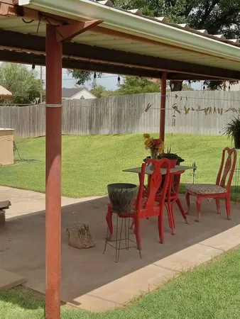 a view of backyard with table and chairs and potted plants