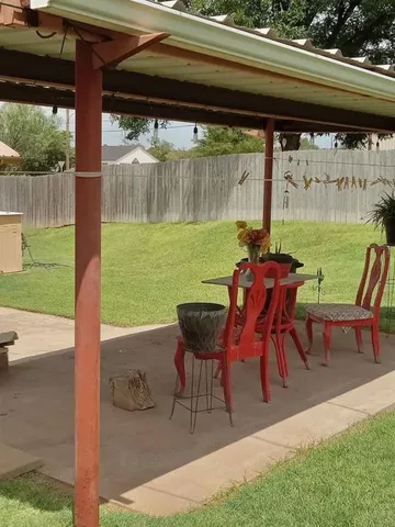 a view of backyard with table and chairs and potted plants