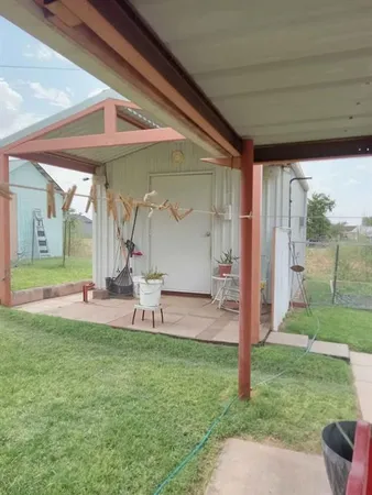 a view of backyard with table and chairs and wooden fence