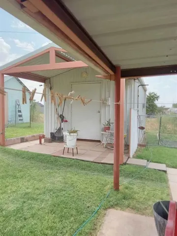 a view of backyard with table and chairs and wooden fence