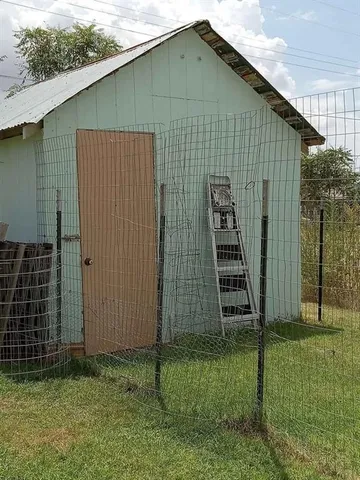 a view of a yard with a tree and a wooden fence