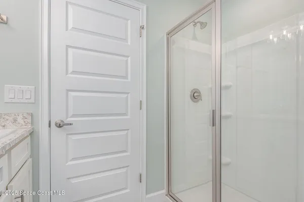 a bathroom with a granite countertop sink toilet a mirror and shower
