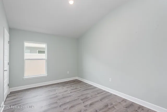 a view of an empty room with wooden floor