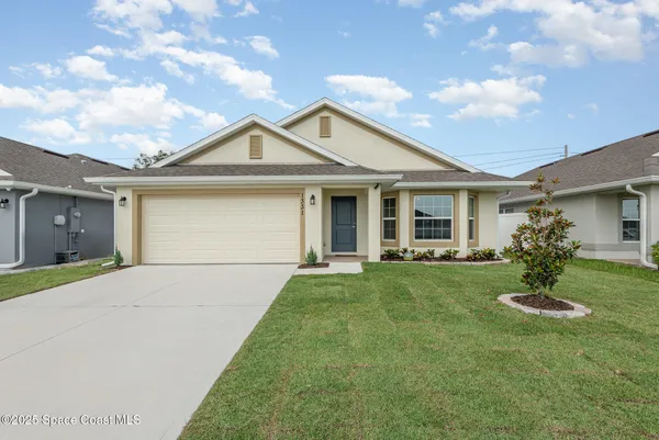 a view of a yard in front of a house with plants and entertaining space
