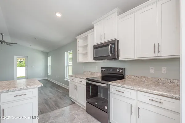a large kitchen with kitchen island a sink stainless steel appliances and cabinets