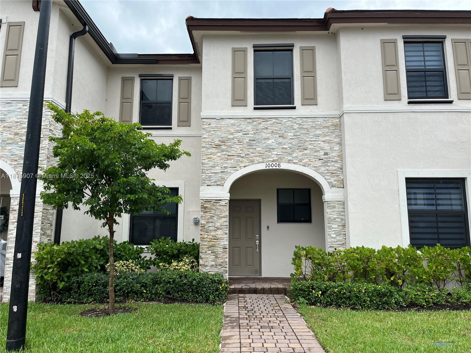 a front view of a house with plants