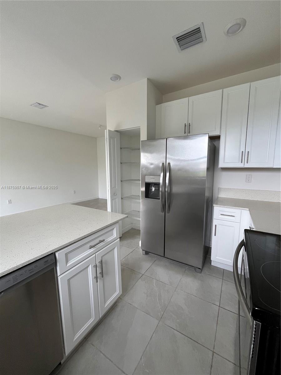10008 Southwest 228th Terrace Miami, FL 33190 - Photo 13 of 46 a kitchen with a refrigerator sink and cabinets