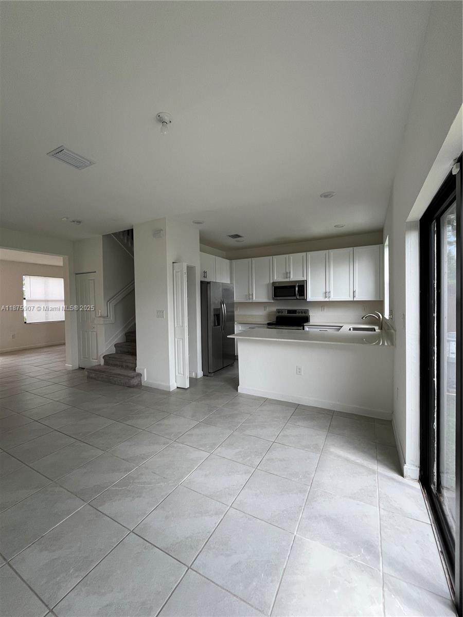 10008 Southwest 228th Terrace Miami, FL 33190 - Photo 15 of 46 a view of kitchen with refrigerator and cabinets