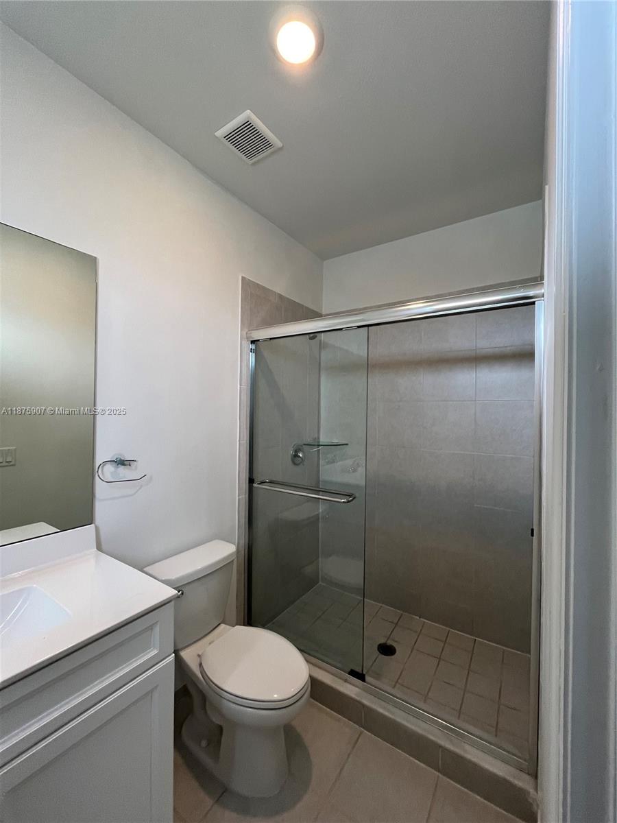 10008 Southwest 228th Terrace Miami, FL 33190 - Photo 19 of 46 a bathroom with a shower a toilet and a sink