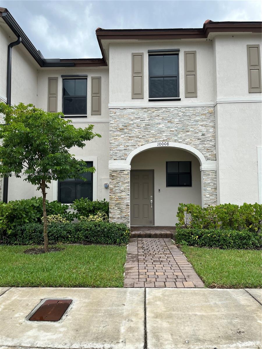 10008 Southwest 228th Terrace Miami, FL 33190 - Photo 2 of 46 a front view of a house with garden