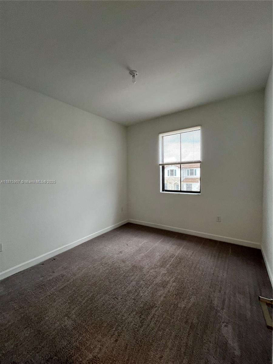 10008 Southwest 228th Terrace Miami, FL 33190 - Photo 27 of 46 an empty room with wooden floor and windows