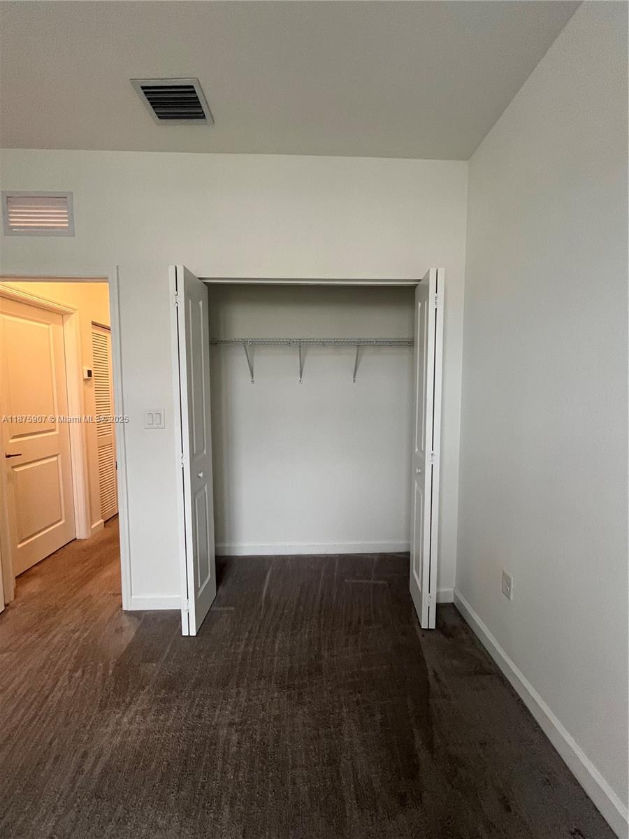 10008 Southwest 228th Terrace Miami, FL 33190 - Photo 30 of 46 an empty room with wooden floor and closet
