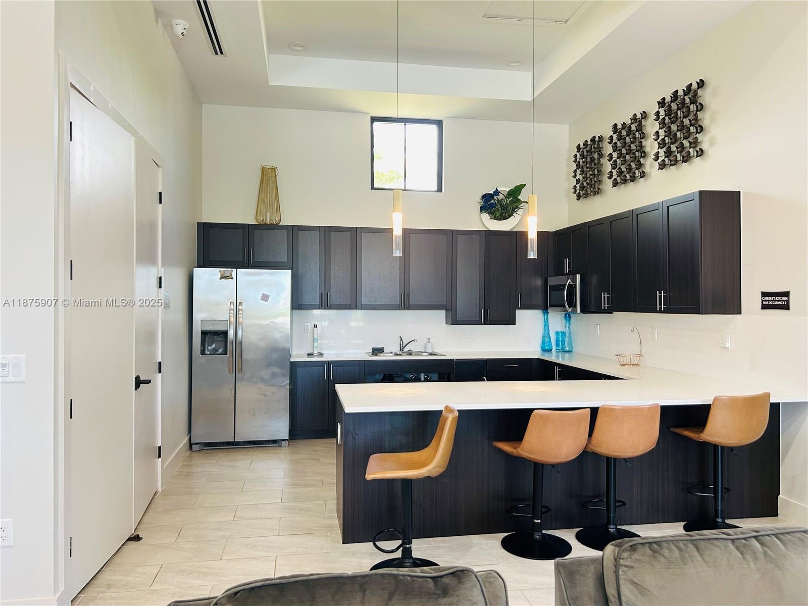 10008 Southwest 228th Terrace Miami, FL 33190 - Photo 36 of 46 a kitchen with stainless steel appliances kitchen island sink refrigerator and stove