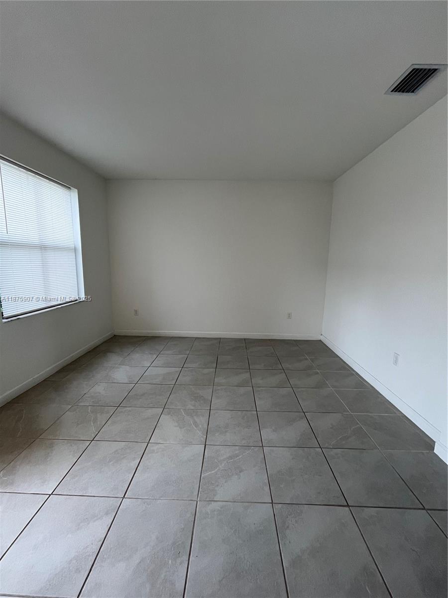 10008 Southwest 228th Terrace Miami, FL 33190 - Photo 6 of 46 a view of an empty room with a window
