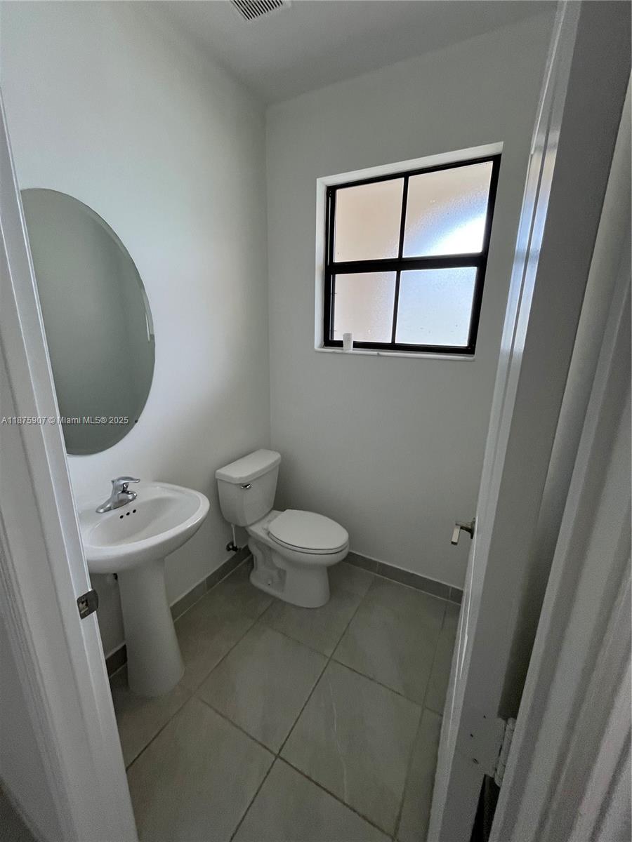 10008 Southwest 228th Terrace Miami, FL 33190 - Photo 7 of 46 a bathroom with a toilet sink and mirror