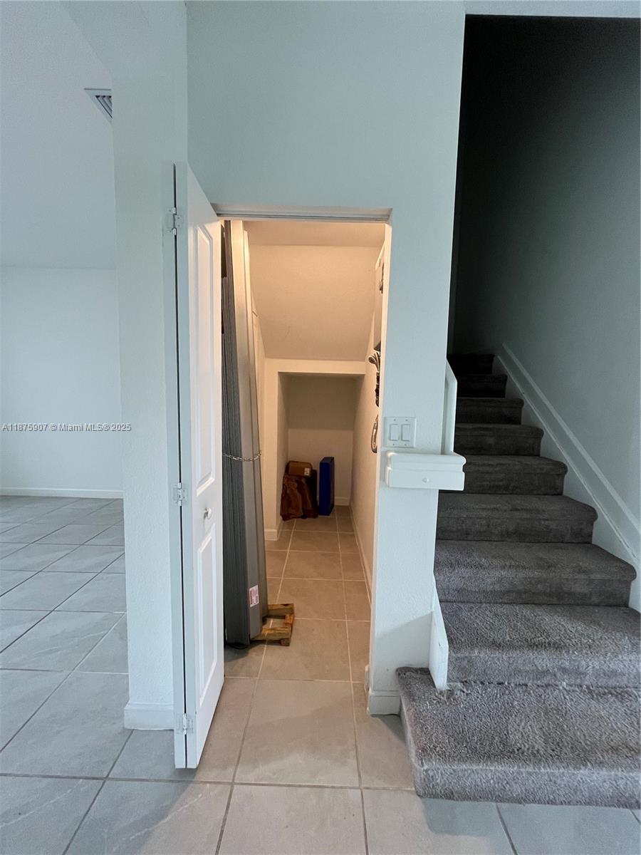 10008 Southwest 228th Terrace Miami, FL 33190 - Photo 10 of 46 a view of staircase with white walls and a window