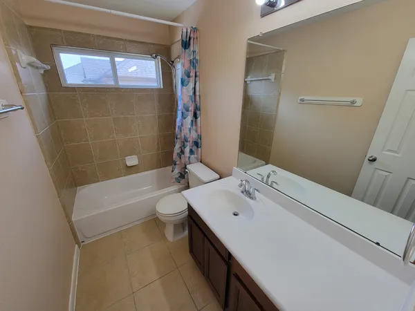 a bathroom with a sink a toilet a mirror and shower