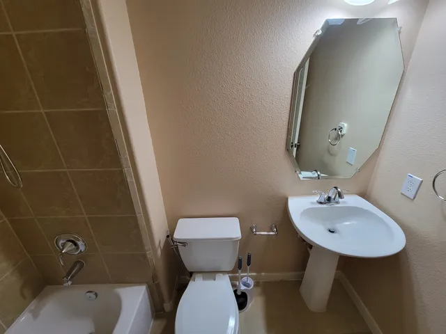 a bathroom with a tub a sink double vanity and a mirror