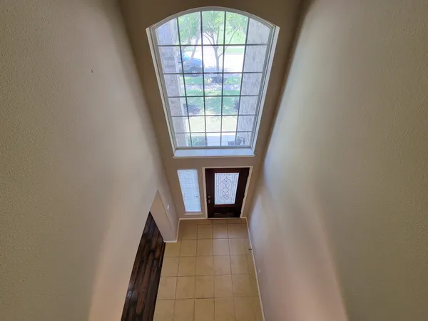 a view of an empty room with a fireplace and a window