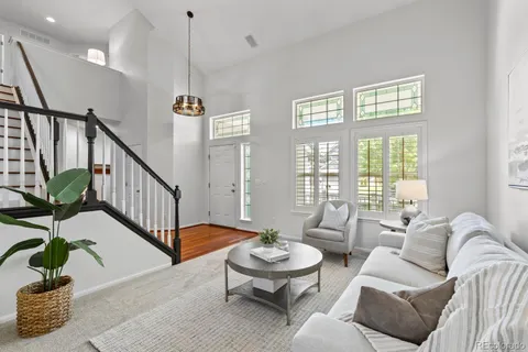 a living room with patio furniture and a potted plant