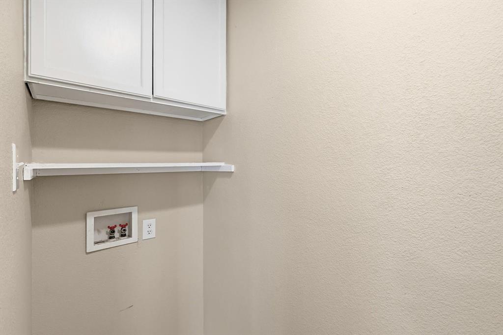 7733 Liz Lane Watauga, TX 76148 - Photo 13 of 27 Laundry area with cabinet space and washer hookup