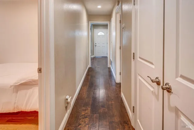 a view of a hallway with wooden floor and stairs