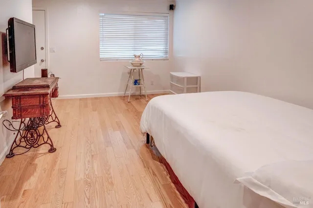 a bedroom with a bed and a flat tv screen on the dresser