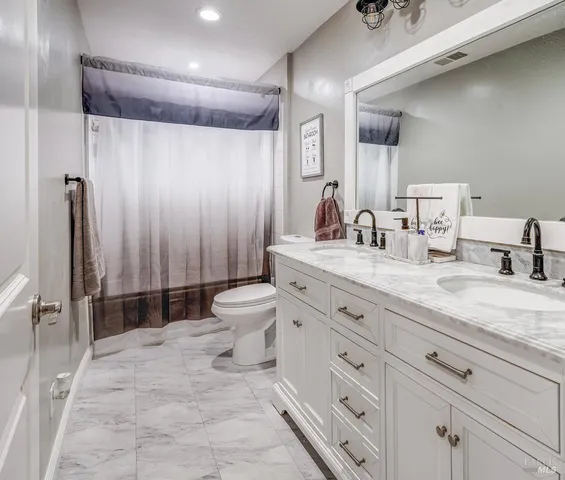 a spacious bathroom with double sink and a mirror
