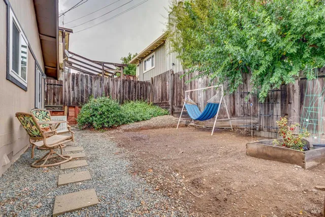 a view of patio with table and chairs potted plants and wooden fence