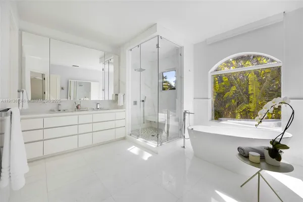 a bathroom with a double vanity sink mirror and bathtub