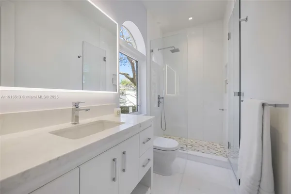a bathroom with a sink a toilet and shower