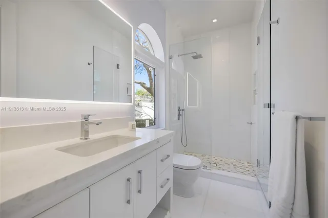 a bathroom with a sink a toilet and shower