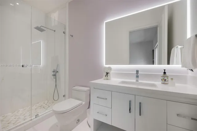 a bathroom with a double vanity sink toilet mirror and shower