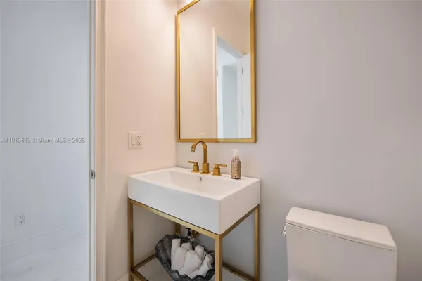 a bathroom with a sink toilet and mirror