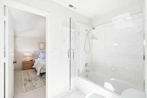 a bathroom with a bathtub shower and toilet