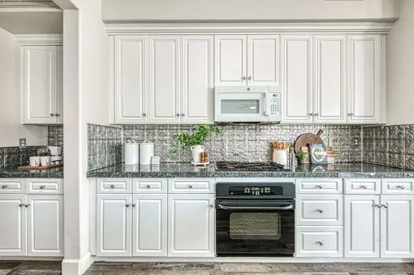 a kitchen with kitchen island a dining table and chairs