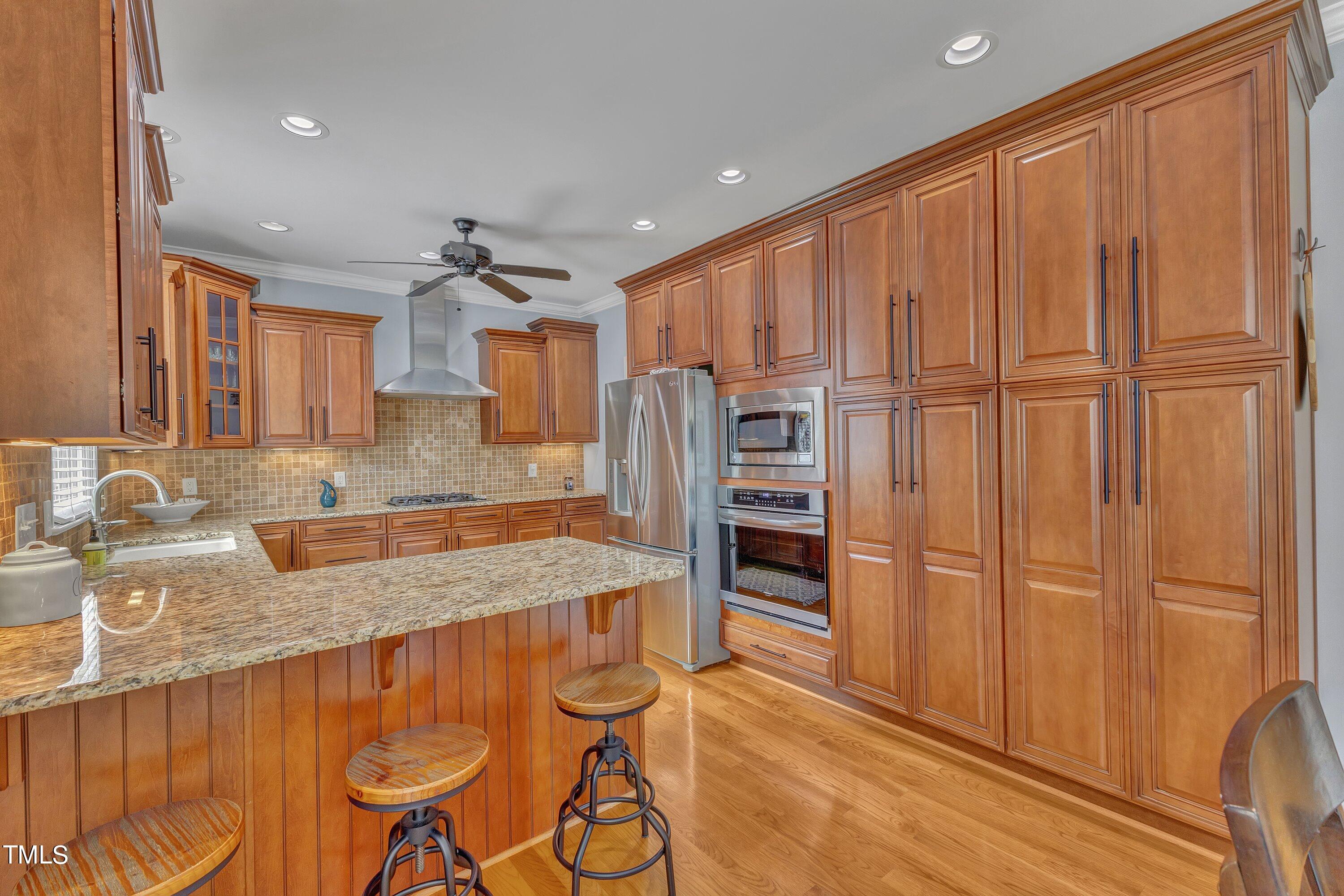 1741 Dunn Maple Drive Wake Forest, NC 27587 - Photo 14 of 63 a kitchen with granite countertop a refrigerator and wooden cabinets