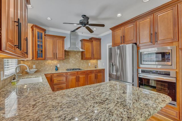 a kitchen with stainless steel appliances granite countertop a refrigerator stove and sink