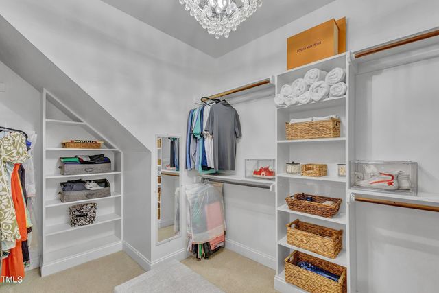 a view of walk in closet with clothes and shoes