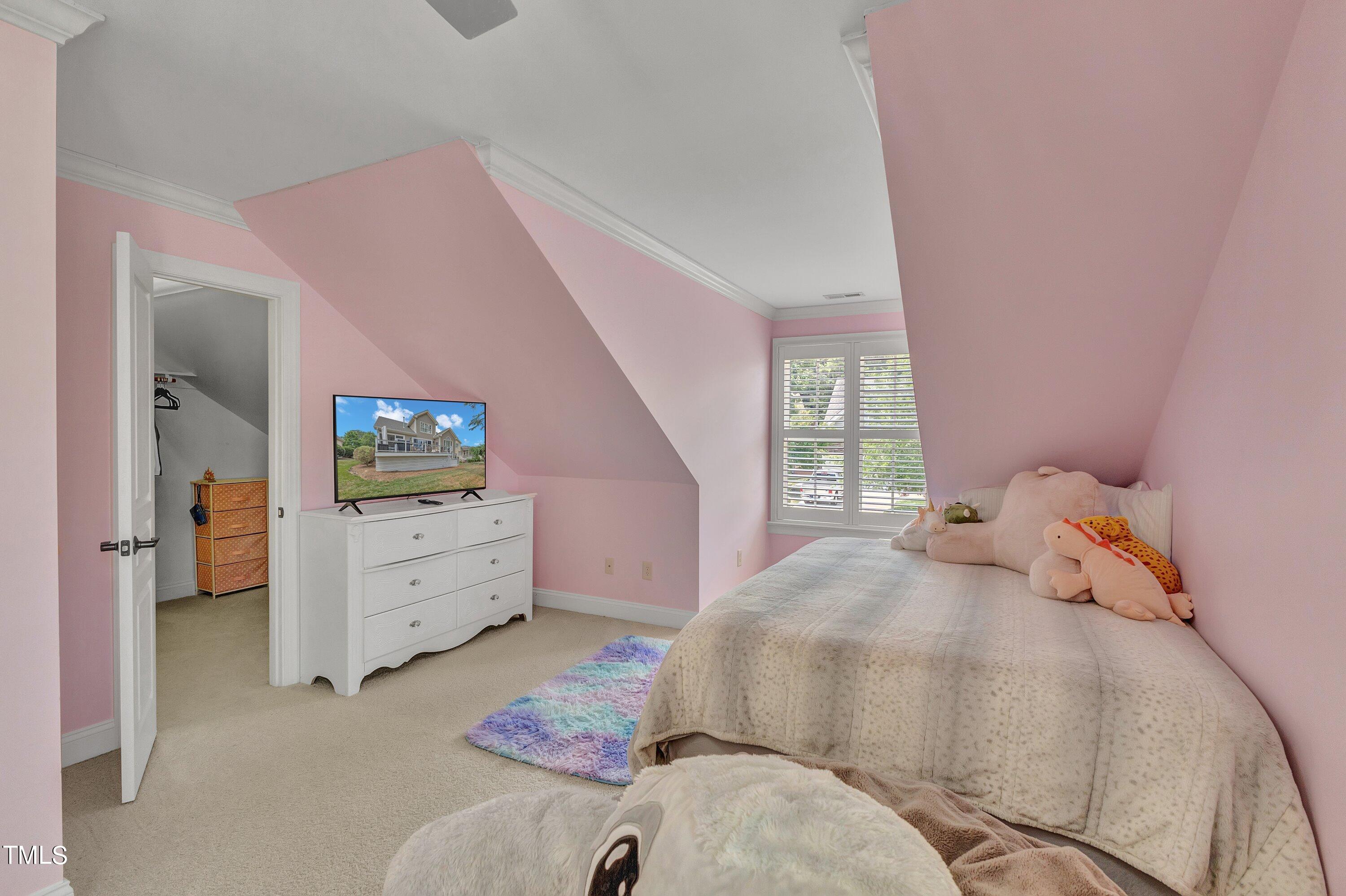 1741 Dunn Maple Drive Wake Forest, NC 27587 - Photo 35 of 63 a bedroom with a bed and a flat tv screen on dresser