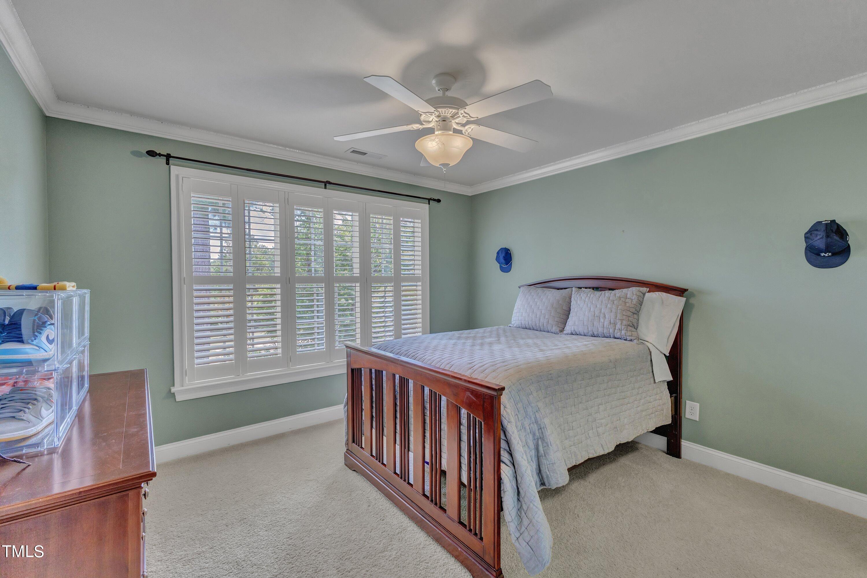 1741 Dunn Maple Drive Wake Forest, NC 27587 - Photo 38 of 63 a bedroom with a bed and a chandelier
