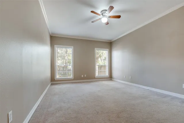 a view of an empty room with a ceiling fan