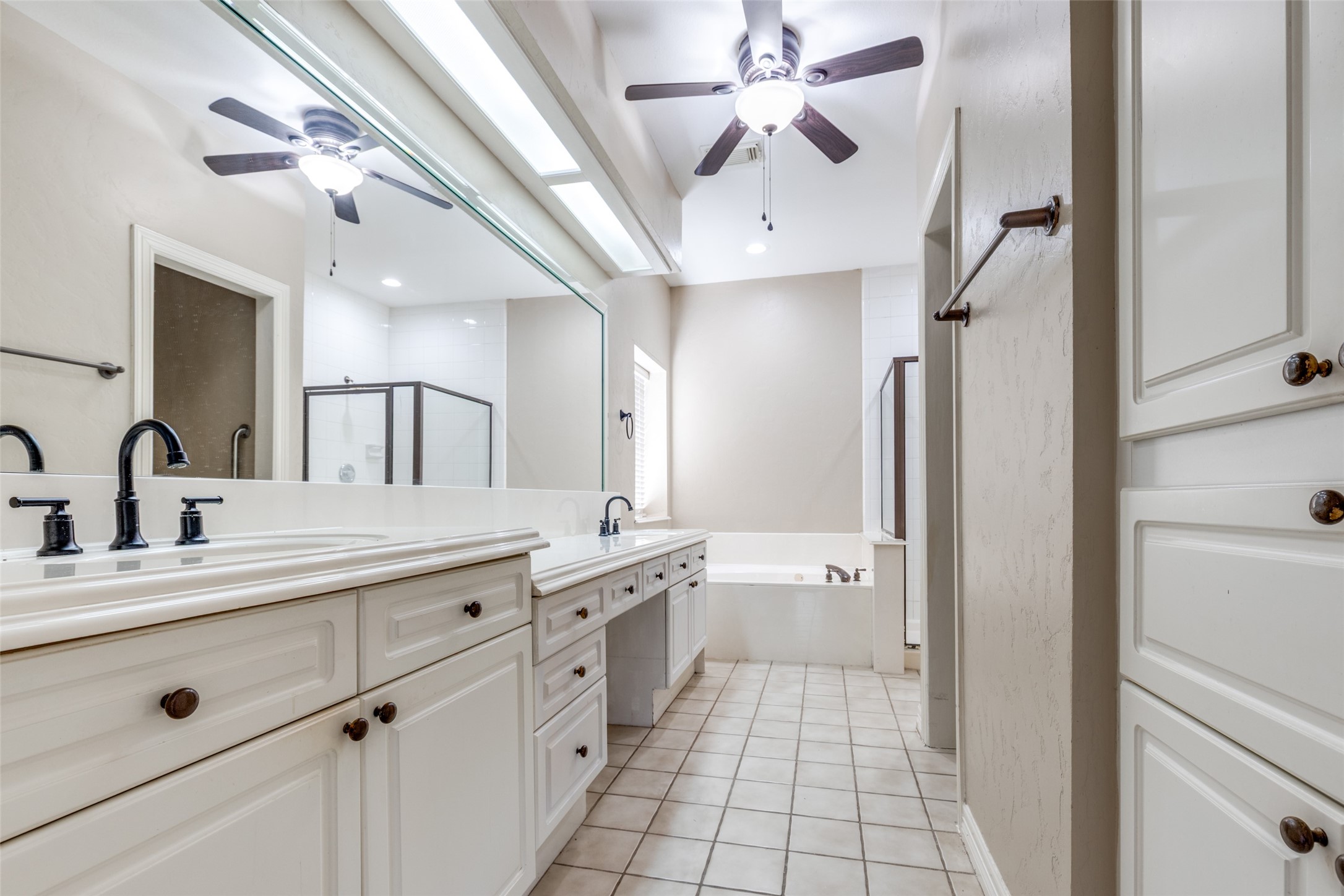 19026 Owen Oak Drive Humble, TX 77346 - Photo 19 of 25 a spacious bathroom with a double vanity sink a large mirror and a shower
