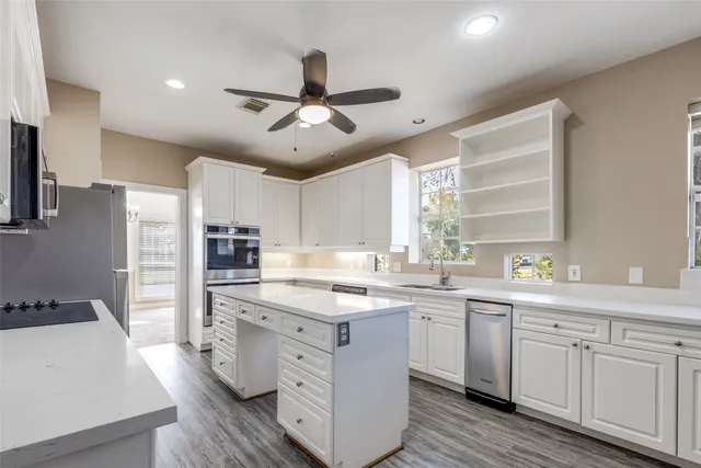 a kitchen with kitchen island granite countertop a sink stainless steel appliances and counter space