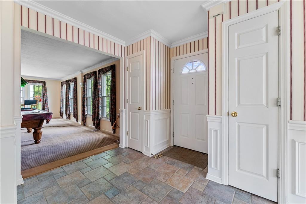 Foyer with view front door, two coat closets, and game room