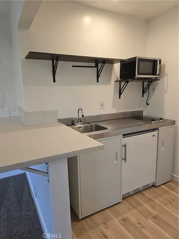 a kitchen with a sink cabinets and wooden floor