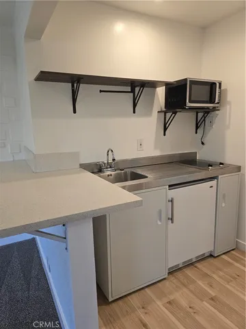 a kitchen with a sink cabinets and wooden floor